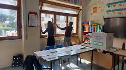 Arezzo, scrutatori puliscono i vetri dell'aula durante una pausa senza elettori
