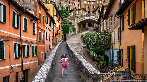 2. Ragazza corre su per la strada. Perugia, Umbria, Italia, 2022 &copy;Steve McCurry