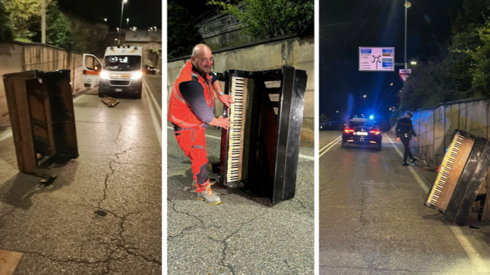 Pianoforte in mezzo alla strada in città, arriva l'ambulanza e lo strumento deve essere spostato per farla passare