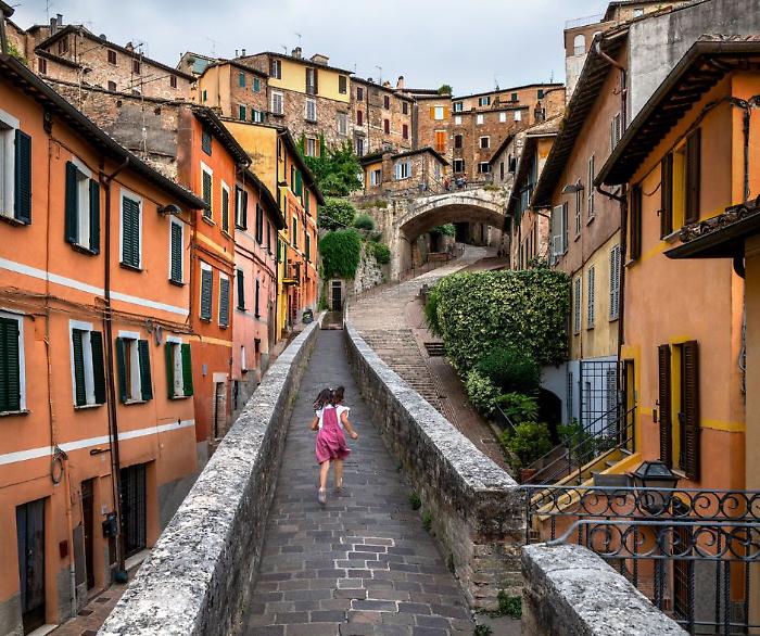 2. Ragazza corre su per la strada. Perugia, Umbria, Italia, 2022 &copy;Steve McCurry
