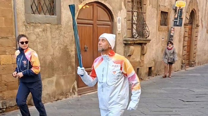 L'ingegnere tedoforo Caleri dopo aver portato la torcia delle Olimpiadi invernali dona la divisa ufficiale al suo Comune